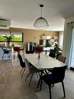 a dining room and living room with a table and chairs at Villa moderne en Provence avec piscine in Carpentras