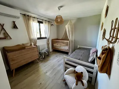 a childs bedroom with a crib and a baby crib at Villa moderne en Provence avec piscine in Carpentras