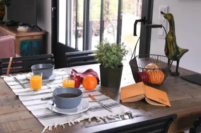 a wooden table with plates of food and oranges on it at Le Galinié Chic'Art. Un bel Atelier avec Piscine in Carpentras