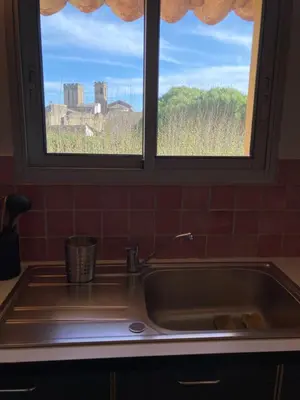 a sink in a kitchen with a window at Grande terrasse CLIM parking privé SMART TV, local velos in Entraigues-sur-la-Sorgue