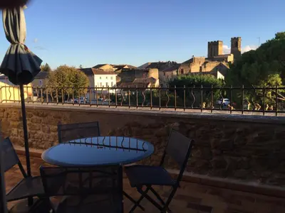 a table and chairs on a balcony with a view of a city at Grande terrasse CLIM parking privé SMART TV, local velos in Entraigues-sur-la-Sorgue