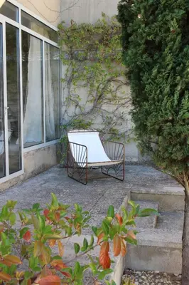 a white bench sitting outside of a building at Maison Les Chênes in Eygalières
