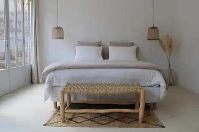 a bedroom with a large bed and a table at Maison Les Chênes in Eygalières