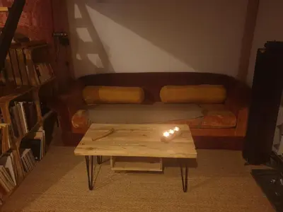 a living room with a couch and a table with a lit candle at Charmant appartement cœur village provençal in Lambesc
