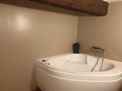 a white bath tub in a corner of a room at Charmant appartement cœur village provençal in Lambesc