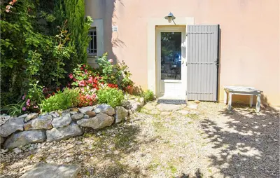 a house with a door and a rock wall at Nice Apartment In Caumont-Sur-Durance in Caumont-sur-Durance
