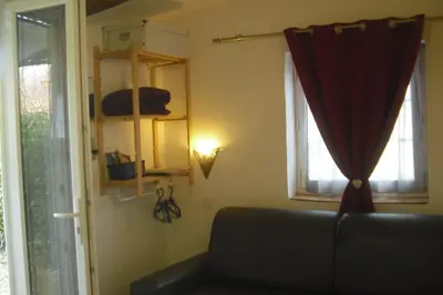 a living room with a couch and two windows at Lou mas li Pitchoun 