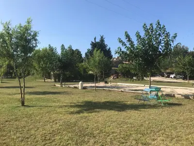 a blue picnic table in a park with trees at Lou mas li Pitchoun 