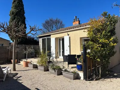 a patio with a table and chairs and trees at Maison Avec jardin clôturé in LʼIsle-sur-la-Sorgue