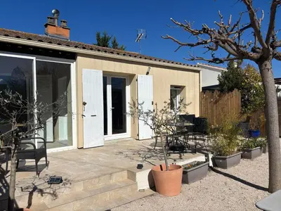 a small house with some plants in a yard at Maison Avec jardin clôturé in LʼIsle-sur-la-Sorgue