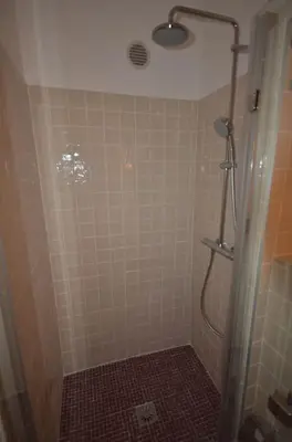 a bathroom with a shower with a tiled wall at LE DIX Duplex historical center balcony with view and air conditioning in Aix-en-Provence