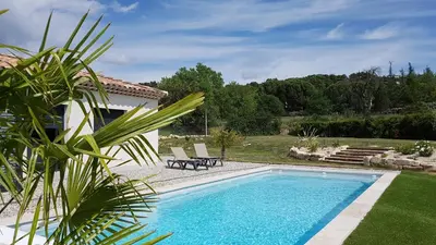 a swimming pool in the yard of a house at L’Abrico’thym in Apt