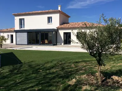 a white house with a tree in the yard at L’Abrico’thym in Apt