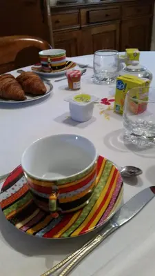 a table with a striped bowl and plates on it at Chambres d'hôtes Elisa & Etienne in Manosque