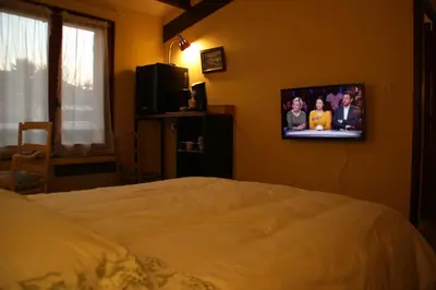 a bedroom with a bed and a tv on the wall at Chambres d'hôtes Elisa & Etienne in Manosque