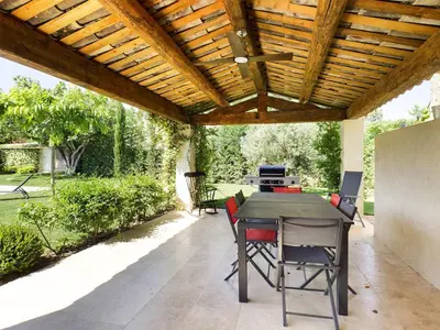 an outdoor patio with a wooden pergola at Villa rénovée à Eygalières avec piscine chauffée - FR-1-599-19 in Eygalières