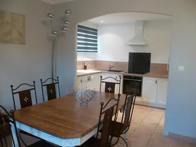 a kitchen with a wooden table and a table and chairs at bastide St Joseph in Eyguières