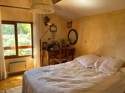 a bedroom with a bed and a desk and a window at Maison provençale en campagne à Eguilles in Éguilles