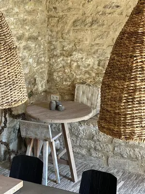 a wooden table in a room with a stone wall at Le Mas de Béthel in Gordes
