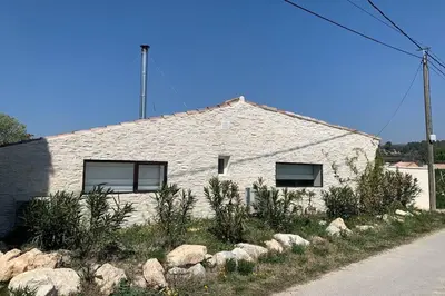 a white brick house with rocks in front of it at Le Cabanon de Modène version 2021 nature in Modène