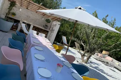 a blue table with chairs and an umbrella at Le Cabanon de Modène version 2021 nature in Modène