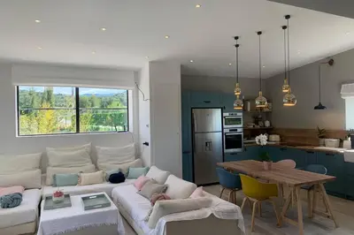 a living room with a white couch and a kitchen at Le Cabanon de Modène version 2021 nature in Modène