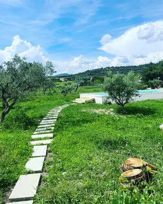 a stone path in the grass next to a body of water at Le Cabanon de Modène version 2021 nature in Modène