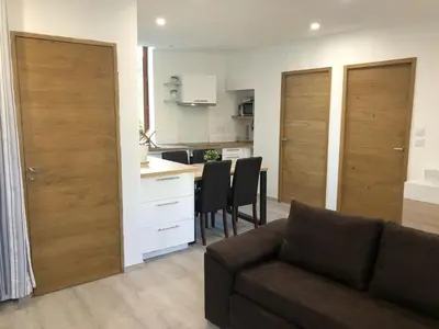 a living room with a couch and a kitchen at Gite au cœur du ventoux in Bédoin