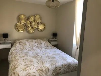 a bedroom with a bed and two mirrors on the wall at Gite au cœur du ventoux in Bédoin