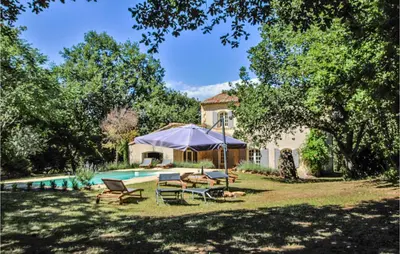 a backyard with a pool with chairs and an umbrella at Pet Friendly Home In Apt in Apt