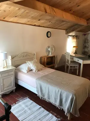 a bedroom with a bed and a table and a desk at La Charmeuse in Céreste
