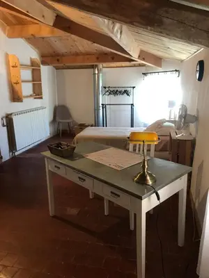 a room with a bed and a desk with a table at La Charmeuse in Céreste