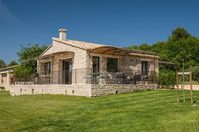 an old stone house with a fence in the yard at Bastide Toujours Dimanche, Maison de vacances avec vue & piscine chauffée in Gordes