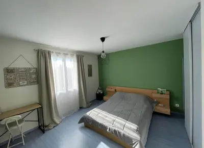 a bedroom with a bed and a green wall at Villa et maisonnette provençales in Carpentras