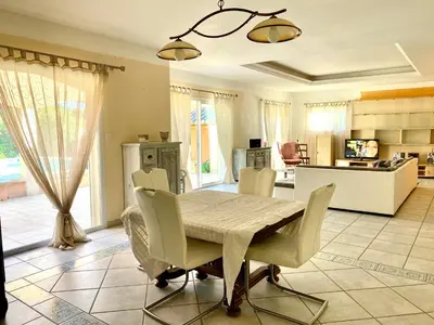 a dining room with a table and chairs at Villa et maisonnette provençales in Carpentras