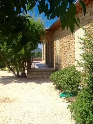 a brick building with a pathway leading to a door at Le temps des cerises in Méthamis