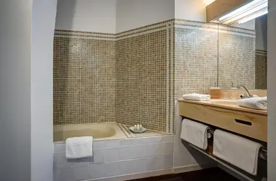 a bathroom with a bath tub and a sink at La Chaumière, Demeure d'hôtes in Lauris