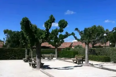 a park with benches and trees in a park at Le Jardin des Alpilles in Eyguières