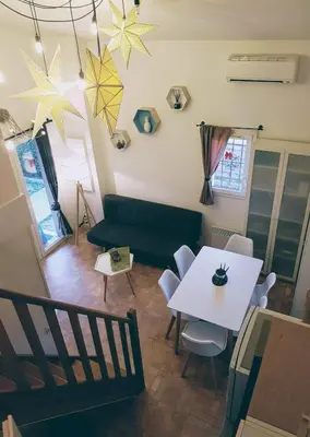 a living room with a table and a couch at Le Jardin des Alpilles in Eyguières