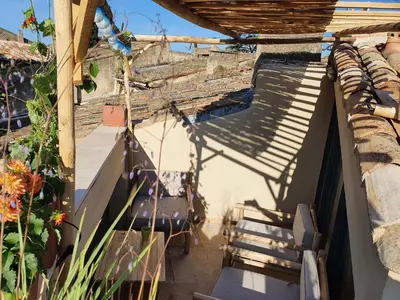 a view of a patio with chairs and a shadow at L'Exquishette de Lourmarin, un nid sur les toits. in Lourmarin