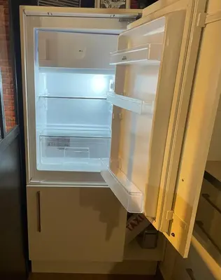 an empty refrigerator with its door open in a kitchen at Appartement et Garage au Cœur de l'Isle in LʼIsle-sur-la-Sorgue