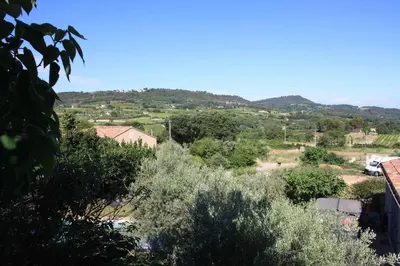 a table and chairs on a balcony with a view at À l'ombre du mûrier in Blauvac