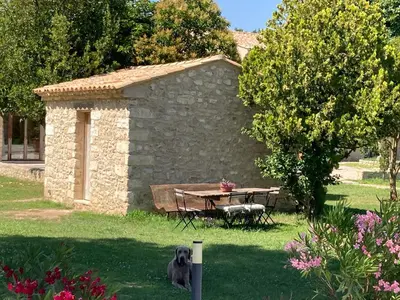 a stone building with a picnic table in a yard at Mas Galinette in Saint-Andiol