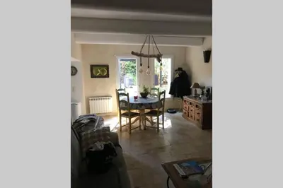 a living room with a table and a chair at Le jardin in Aix-en-Provence