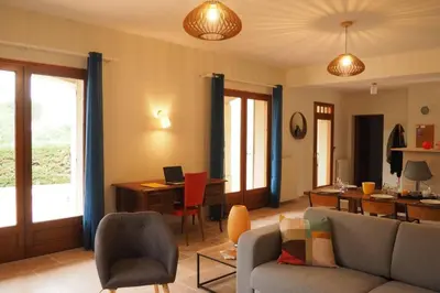 a living room with a couch and a desk at Maison Le Grand Verger in Goult