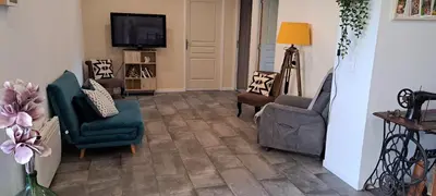 a living room with chairs and a flat screen tv at Gîte 