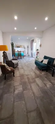 a living room with couches and chairs and a tile floor at Gîte 