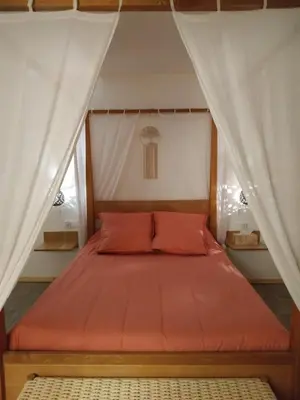 a bed with an orange bedspread in a room at La ferme des Escampades in Monteux