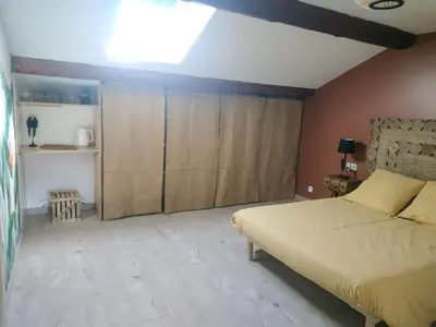 a bedroom with a bed and wooden cabinets at La ferme des Escampades in Monteux
