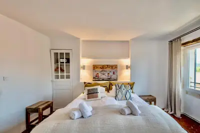 a bedroom with a large white bed with two pillows at Au Ralenti du Lierre in Beaumettes